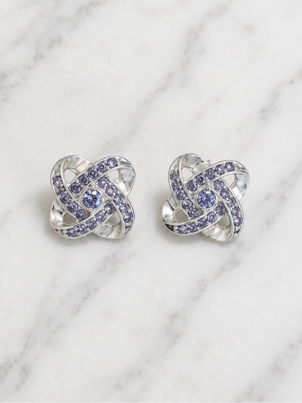 Silver tone knot stud earrings with lavender sparkling rhinestones